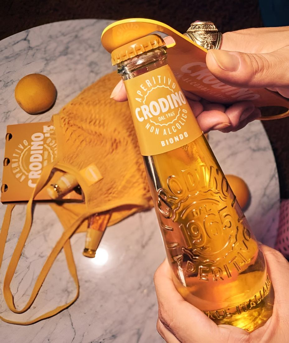 A Crodino bottle being opened over a marble table
