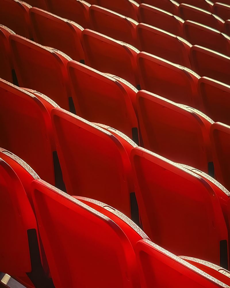 Rows of red stadium seats in evening light
