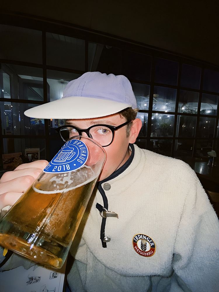 A tilted glass of lager being drunk in a bar